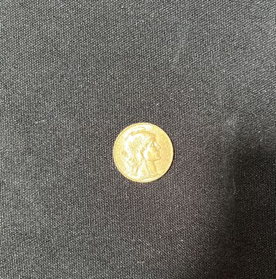 a close up of a gold coin on a black cloth
