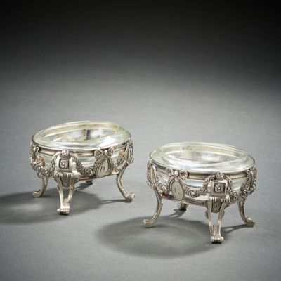 pair of silverplated dishes on pedestals on grey background