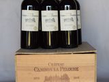 quatre bouteilles de vin se trouvent dans une caisse en bois posée sur une table