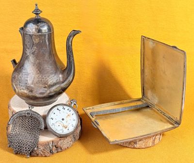 une théière en argent posée à côté d'une autre théière en argent