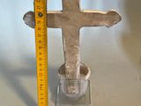 someone is measuring the height of a cross with a ruler