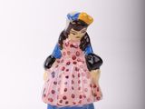 a small figurine of a woman in a pink dress