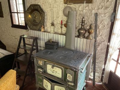 un vieux poêle dans un coin d'une pièce où se trouve une chaise