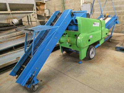 une photo d'une machine bleue et verte dans un entrepôt
