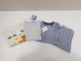 a pile of baby clothes on a white table