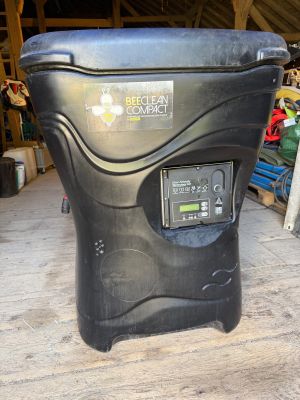 a black trash can sitting on a wooden floor in a garage