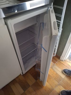 un réfrigérateur blanc dont la porte est ouverte, dans une cuisine
