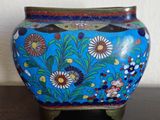 a blue vase with flowers on it on a table