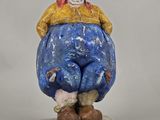an image of a figurine of a man sitting on top of a rock