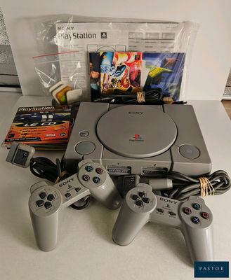 une console de jeux vidéo posée sur une table à côté d'autres objets