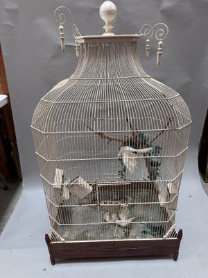 a bird in a cage that is sitting on a table