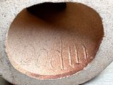 a close up of a clay vase with a hole in it