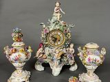 a clock that is sitting on a table next to three vases