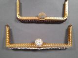 two pieces of gold and silver jewelry on display on a gray surface