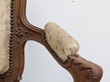 a wooden chair with a beige upholstered cushion on it