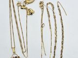 a group of gold necklaces and bracelets on a white surface