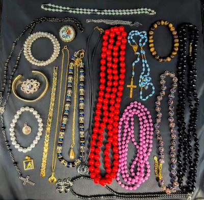Divers colliers et bracelets sont présentés sur un fond noir