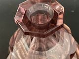 a pink glass candle holder sitting on top of a table