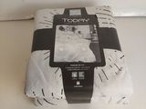 une nappe blanche posée sur une table blanche, ornée d'un motif noir et blanc