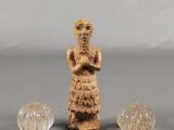deux petites figurines représentant une femme et deux petites boules en verre