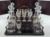 bottles and glasses on a wooden tray with a mirror in the background