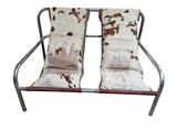 two brown and white cowhided chairs sitting next to each other