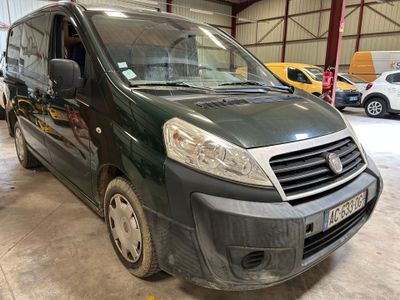 La camionnette verte est garée dans un garage avec d'autres voitures.