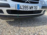 a small silver car parked in a gravel lot