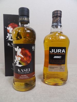 deux bouteilles d'alcool posées l'une à côté de l'autre sur une table