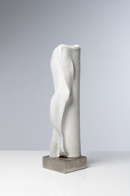 sculpture représentant le torse d'une femme, posée sur un socle, sur une surface blanche