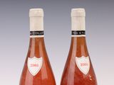 two bottles of wine are sitting on a white surface