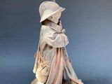 statue of a boy sitting on a book with a baseball bat in his hand