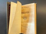 an open book sitting on top of a metal stand on a table