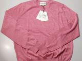a close up of a pink sweater with a tag on it