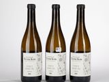 trois bouteilles de vin posées l'une à côté de l'autre sur une table