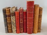 plusieurs vieux livres sont alignés sur une surface blanche