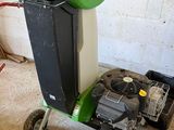 une poubelle verte et noire posée sur un chariot dans un garage