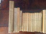 several old books are lined up on a wooden table