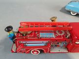 a toy fire truck and a toy car on a table