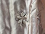 a close up of a white shirt with a flower on it