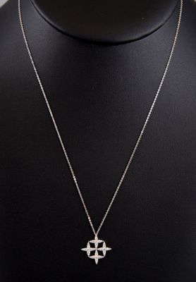 un collier avec un pendentif en forme de croix autour du cou d'un mannequin