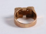an image of a gold ring on a white surface