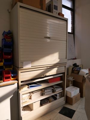 une armoire au milieu d'une pièce, avec de nombreuses boîtes par terre