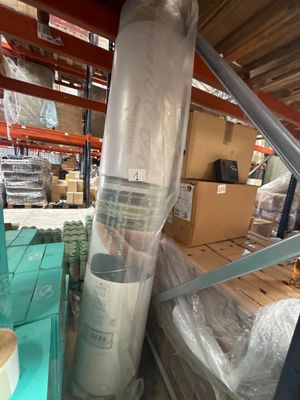 un gros rouleau de plastique posé sur une palette dans un entrepôt