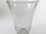 the small glass vase is sitting on a white surface