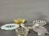 several glass dishes and spoons sitting on a gray surface