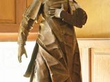 une statue représentant une femme debout sur une table dans une pièce