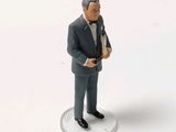 a figurine of a man in a tuxedo holding a bottle of wine