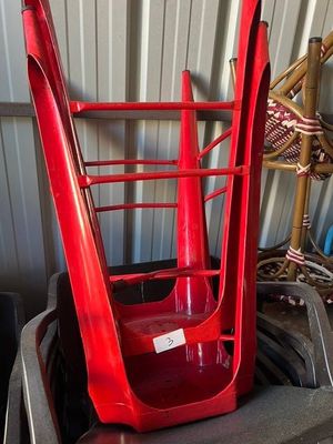 a red chair that is sitting on top of a trash can