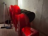 several red plastic chairs are lined up against a wall in a dark room